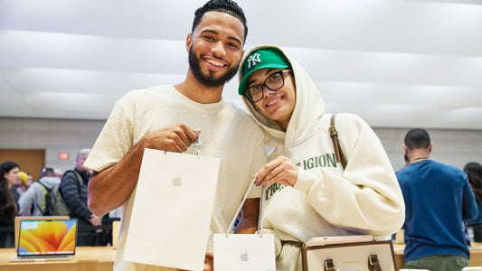 Clientes en Apple 5th Avenue, Nueva York, con productos Apple, los mejores regalos para Navidad.